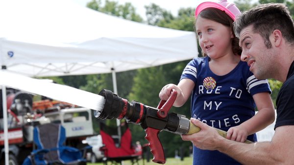 Girl with fire hose at EcoFest.jpg