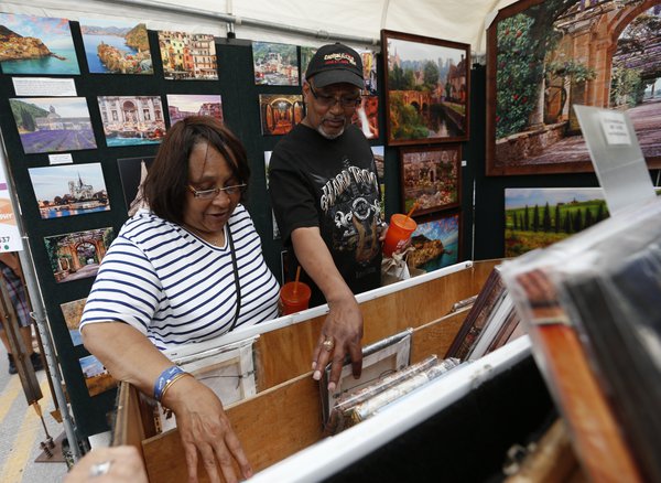 Two Arts Festival attendees browse the selection of prints in a landscape photographer’s booth. Credit - Greg Bartram.jpg